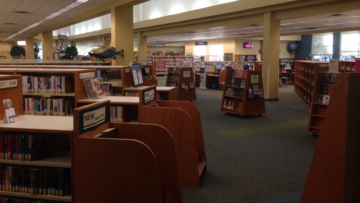 Library Shelves and New Book Displays at Avon Lake Public library floor with low wooden shelves, a large print section sign and new book displays ready for holds and browsing